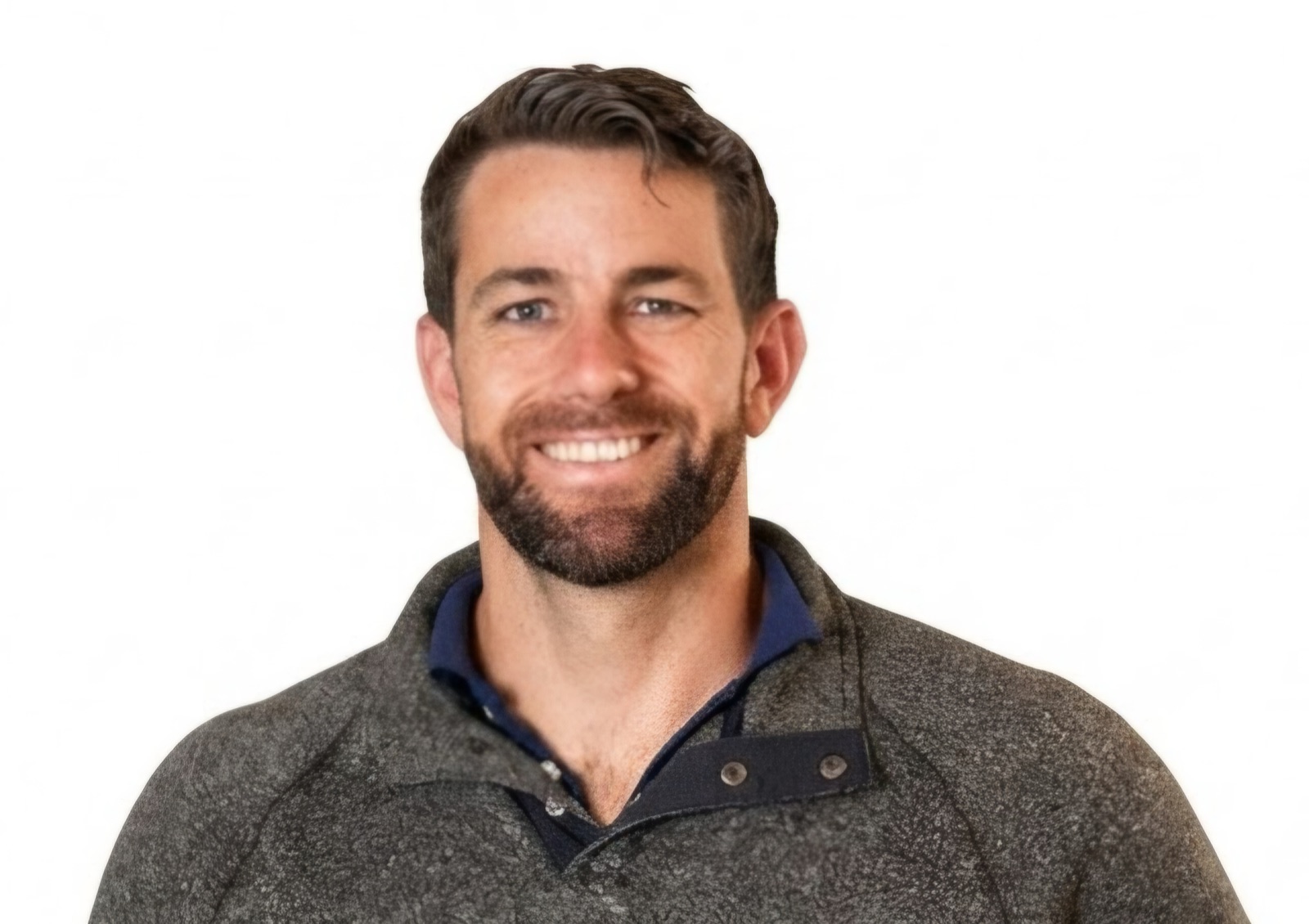 Philip Dettinger, smiling, in a grey knit pullover over a navy collared shirt, against a white background.